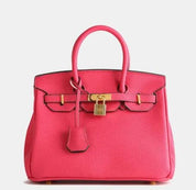 Borsa Birkin rosa acceso in pelle con chiusura a lucchetto dorato, manici arrotondati. Elegante accessorio di lusso per moda femminile.